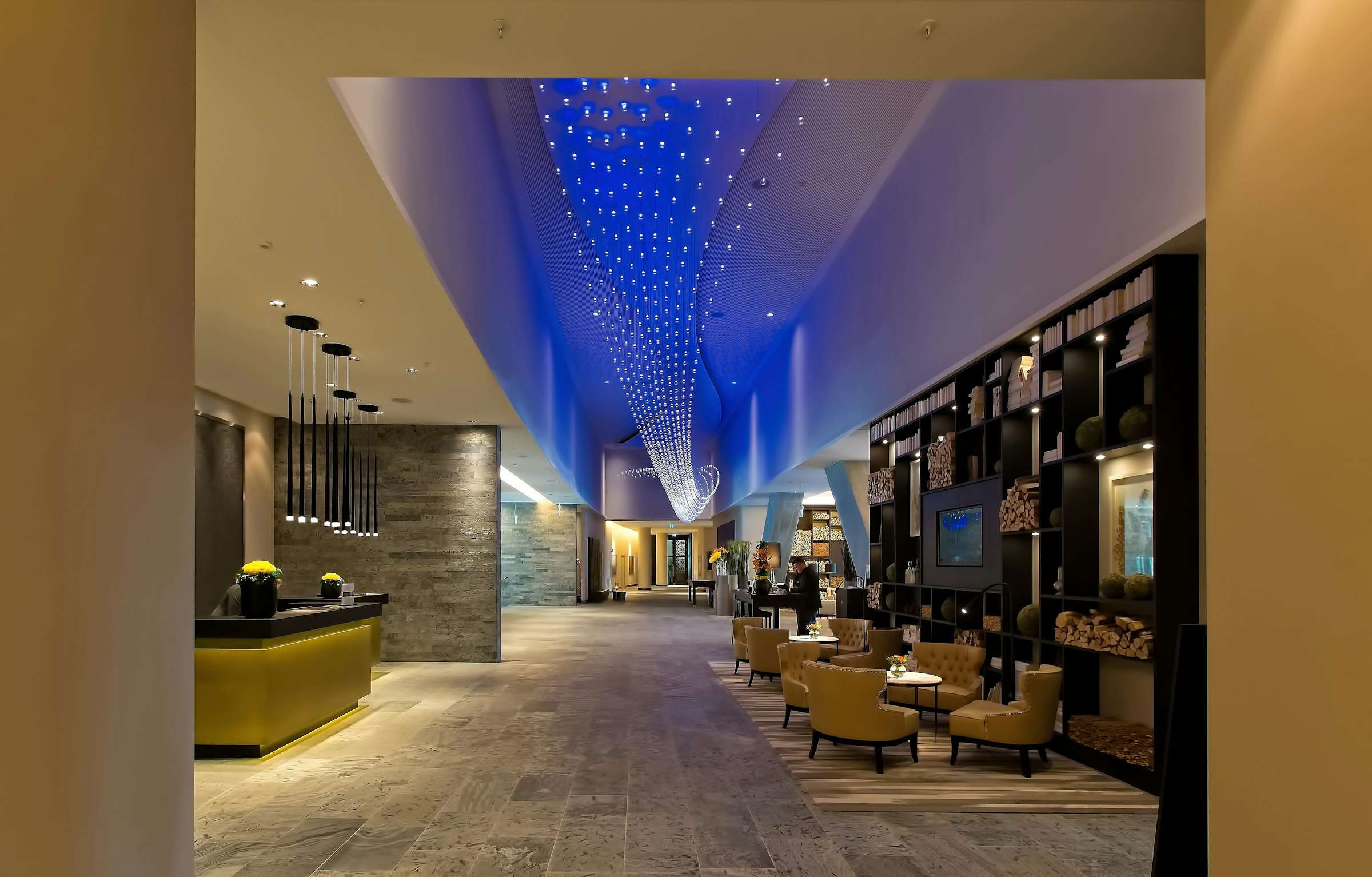 Voorbeeldfoto: een lobby met een blauwe lichtlijn in het plafond en een scherm ingebouwd in een wandkast.